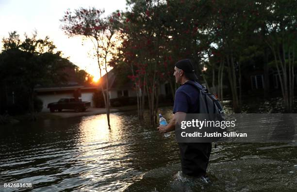 Samir Novruzov walks through a flooded street on September 4, 2017 in Katy, Texas. Over a week after Hurricane Harvey hit Southern Texas, residents...