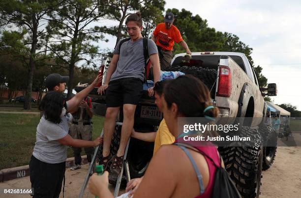 People climb out of a monster truck that helped transport them through floodwaters on September 4, 2017 in Katy, Texas. Over a week after Hurricane...