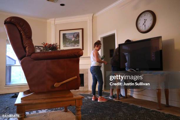 Emily Teague helps her brother Andrew Teague move a television as they clean out her flooded home on September 4, 2017 in Katy, Texas. Over a week...