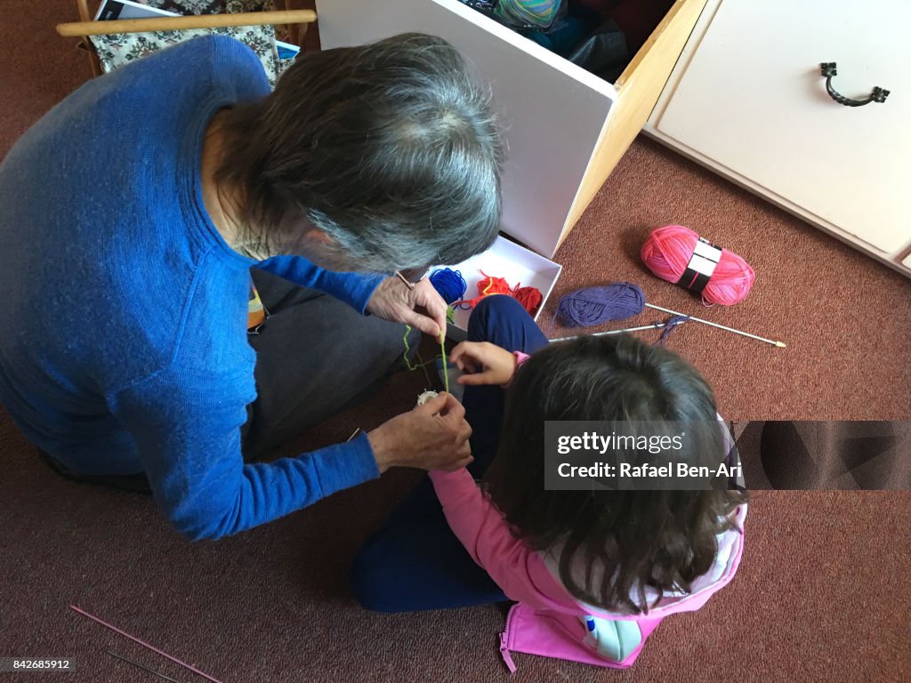 Grandmother teaching her granddaugther to sew