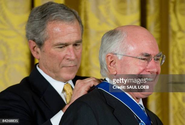 President George W. Bush presents the Presidential Medal of Freedom to Australia's former Prime Minister John Howard in the East Room of the White...