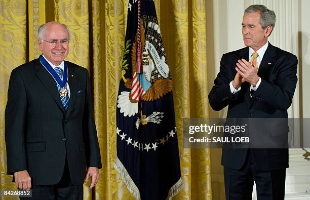 President George W. Bush presents the Presidential Medal of Freedom to Australia's former Prime Minister John Howard in the East Room of the White...