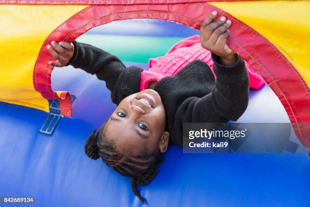 little girl playing in bounce house - bouncy castle stock pictures, royalty-free photos & images