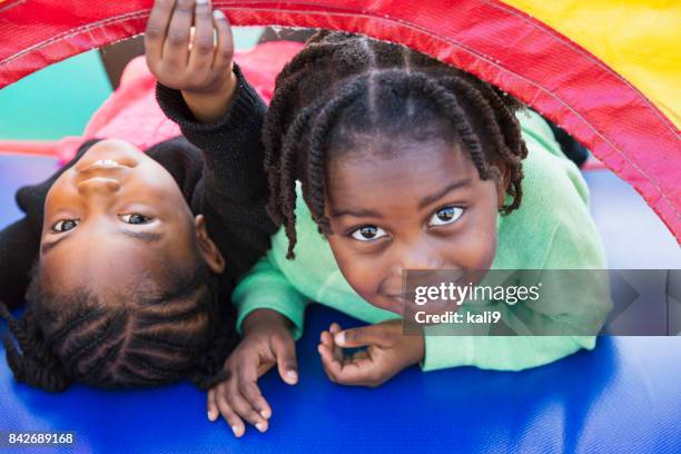 two children playing in bounce house - cornrows stock pictures, royalty-free photos & images