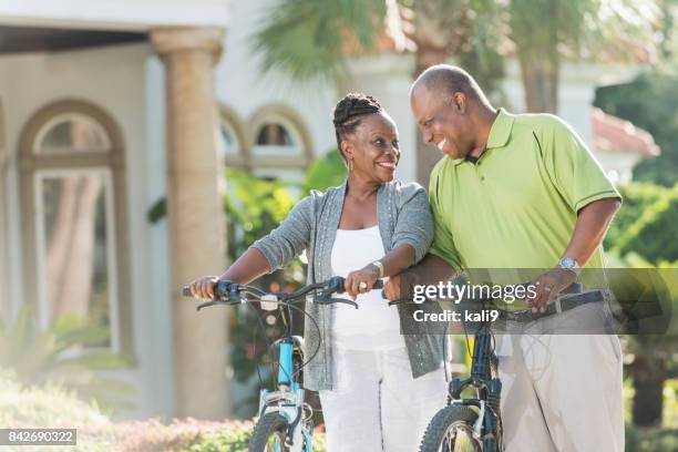 senior african-american couple riding bicycles - early retirement stock pictures, royalty-free photos & images