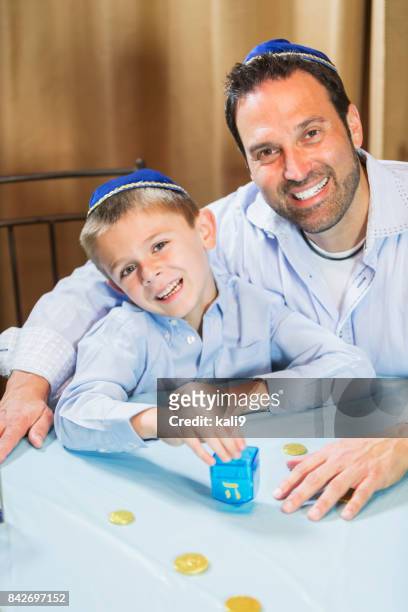 little boy and father playing dreidel - skull cap stock pictures, royalty-free photos & images