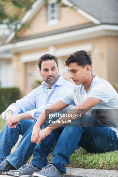 father sitting with serious teenage boy - dad advice stock pictures, royalty-free photos & images