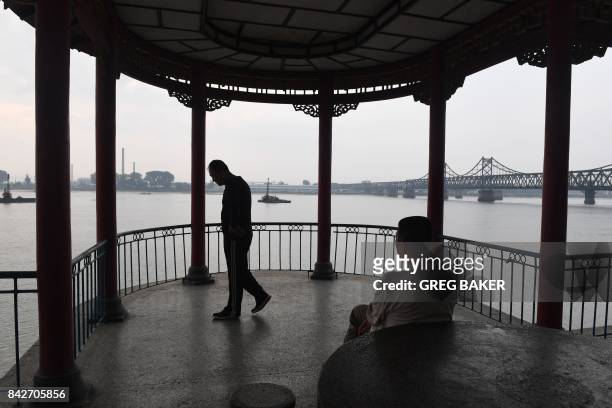Chinese man walks in a pagoda on the waterfront in Dandong, in China's northeast Liaoning province, opposite the North Korean town of Sinuiju, across...