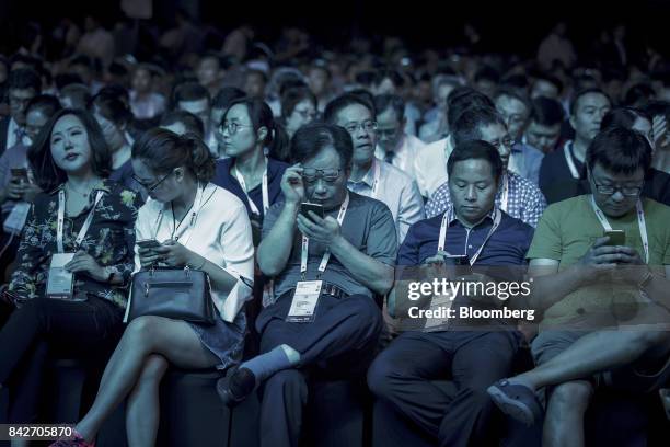 Attendee uses their smartphones ahead of the keynote address at the Huawei Connect 2017 conference in Shanghai, China, on Tuesday, Sept. 5, 2017....