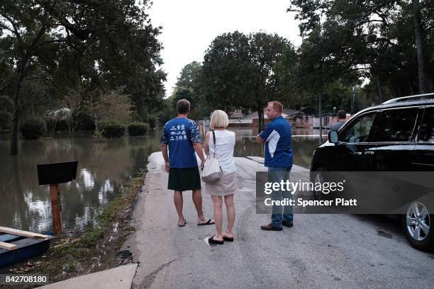 People stand in a flooded neighborhood as Texas moved toward recovery from the devastation of Hurricane Harvey on September 4, 2017 in Houston,...