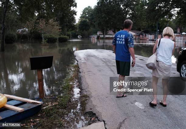 Couple stands in a flooded neighborhood as Texas moved toward recovery from the devastation of Hurricane Harvey on September 4, 2017 in Houston,...