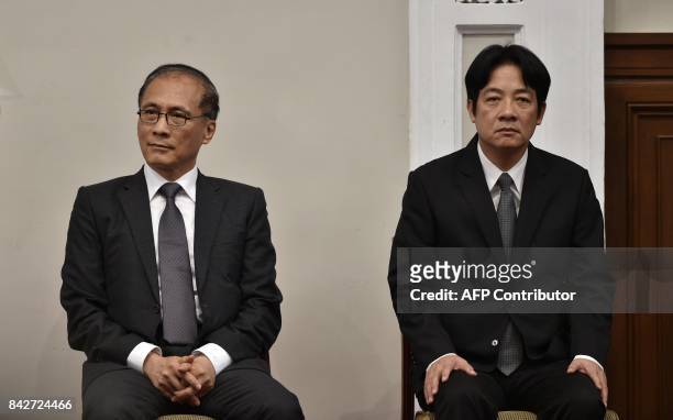 Outgoing Taiwan premier Lin Chuan sits next to newly appointed Premier William Lai during a press conference at the Presidential Palace in Taipei on...