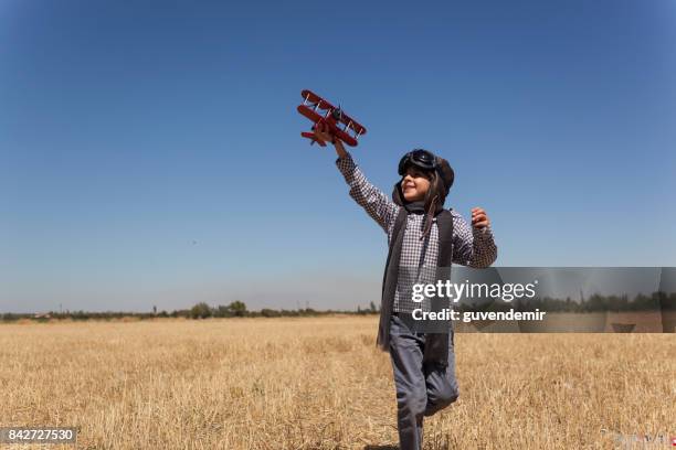 boy playing with toy airplane - aviation hat stock pictures, royalty-free photos & images