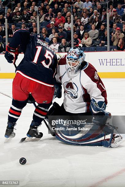 Goaltender Andrew Raycroft of the Colorado Avalanche makes a save as Derek Dorsett of the Columbus Blue Jackets battles for position in front of the...