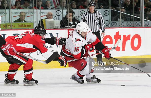 Chris Phillips of the Ottawa Senators hooks Tuomo Ruutu of the Carolina Hurricanes at Scotiabank Place on January 13, 2009 in Ottawa, Ontario, Canada.