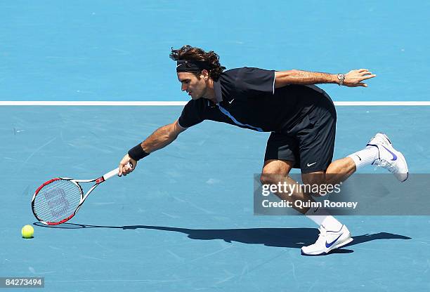 Roger Federer of Switzerland stretches for a forehand volley during his match against Carlos Moya of Spain during day one of the AAMI Classic at the...