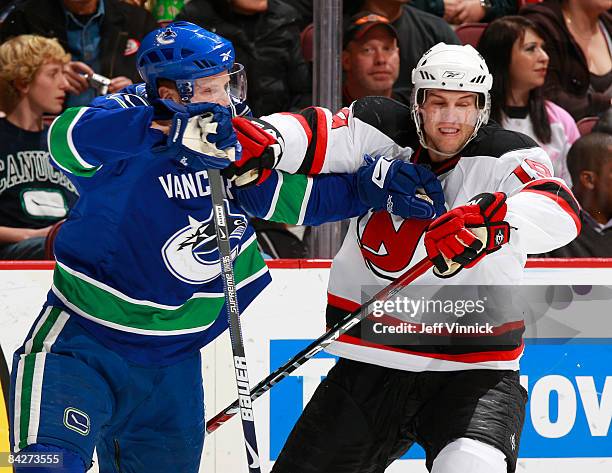 Henrik Sedin of the Vancouver Canucks and Travis Zajac of the New Jersey Devils keep each other in check during their game at General Motors Place on...