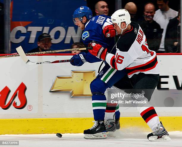 Robert Holik of the New Jersey Devils pushes Alexander Edler of the Vancouver Canucks along the boards during their game at General Motors Place on...