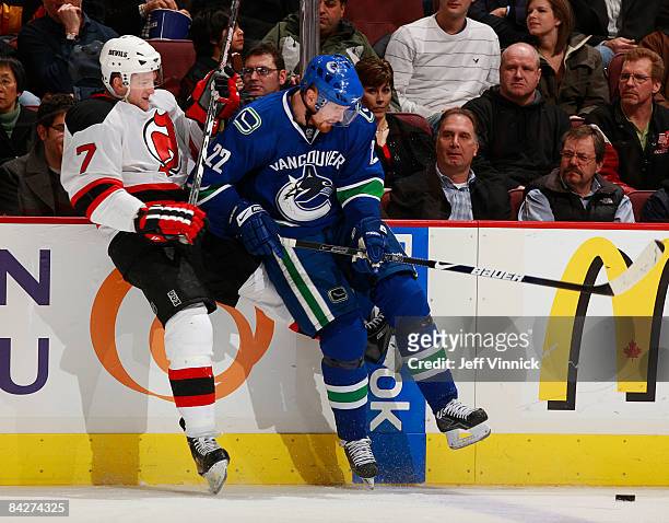 Daniel Sedin of the Vancouver Canucks and Paul Martin of the New Jersey Devils battle for the puck during their game at General Motors Place on...
