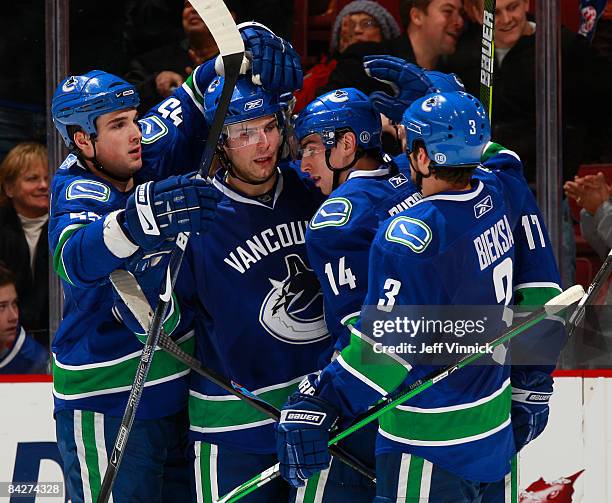 Steve Bernier of the Vancouver Canucks is congratulated by teammates Shane O'Brien, Alex Burrows and Kevin Bieksa after scoring against the New...