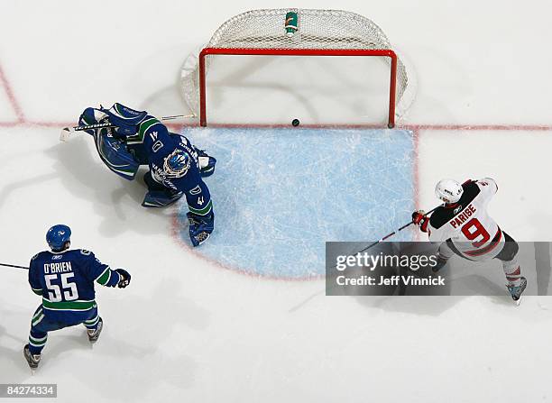 Shane O'Brien and Curtis Sanford of the Vancouver Canucks look on as Zach Parise of the New Jersey Devils scores during their game at General Motors...