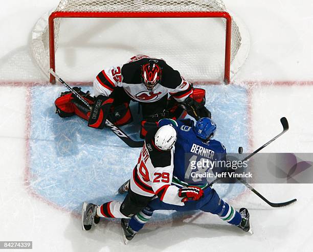 John Oduya of the New Jersey Devils and Steve Bernier of the Vancouver Canucks battle for the rebound after Scott Clemmensen of the New Jersey Devils...