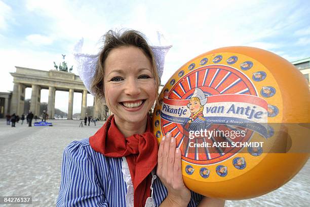 Woman dressed as a Dutch "Meisje Antje" presents a cheese in front of Berlin's landmark the Brandenburg Gate on January 14, 2009 to promote the...