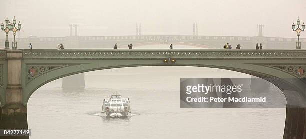 People walk across Westminster Bridge over a foggy River Thames on January 14, 2009 in London, England. Temperatures in the capital are expected to...
