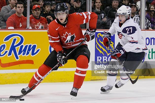 Colten Teubert of Team Canada skates with the puck while being chased by Drayson Bowman of Team USA at the IIHF World Junior Championships at the...