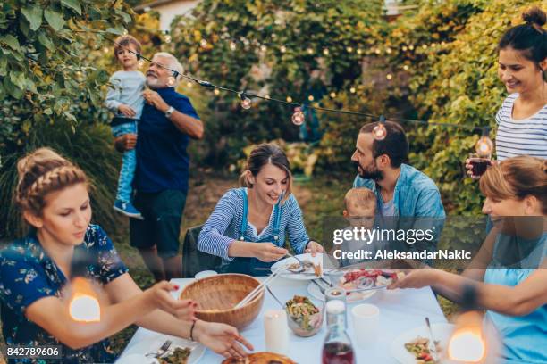mehr-generationen-familie bei einer dinner-party - gartenparty stock-fotos und bilder