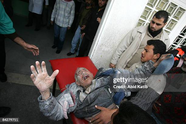 Palestinians carry an elderly man, wounded in an Israeli military strike, into Kamal Adwan hospital January 14, 2009 in of Beit Lahia, in the...
