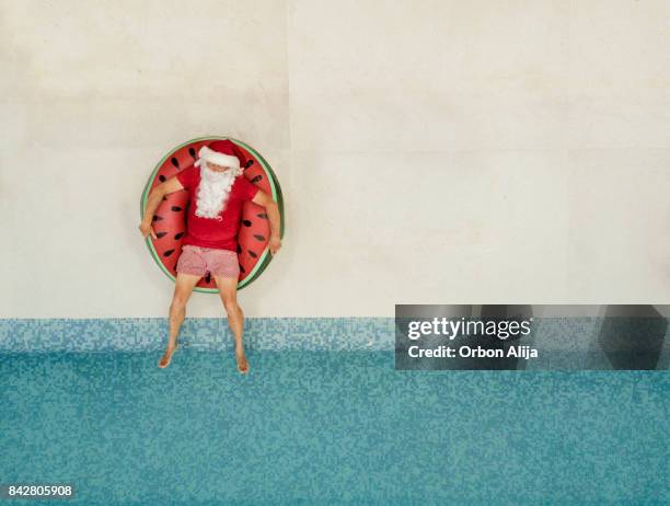 santa claus relajante en la piscina - santa claus fotografías e imágenes de stock