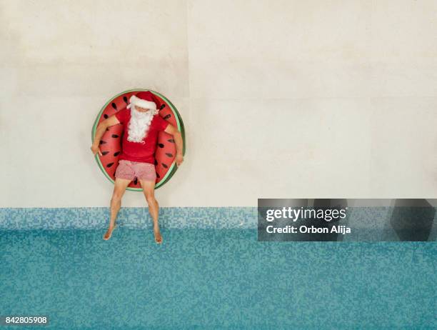 santa claus relaxing at the pool - funny pics of people imagens e fotografias de stock