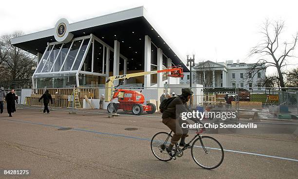 Bicyclist moves along Pennsylvania Avenue in front of the Inaugural parade review stand in front of the White House on January 14, 2009 in...