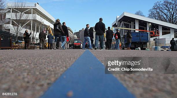 People walk along Pennsylvania Avenue in front of the Inaugural parade review stand between Lafayette Park and the White House on January 14, 2009 in...