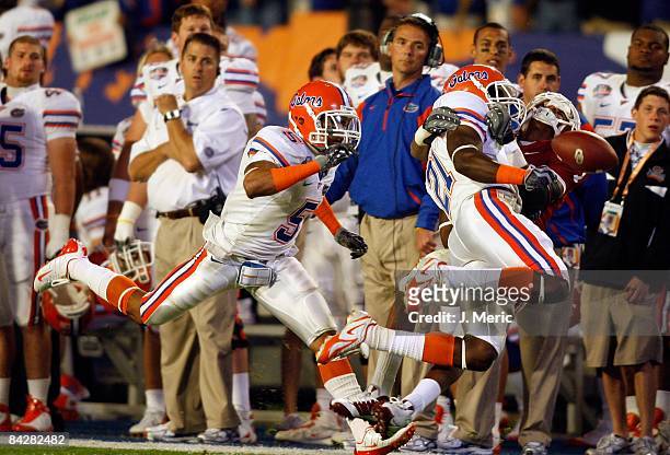 Receiver Manuel Johnson of the Oklahoma Sooners is separated from the ball by safety Major Wright of the Florida Gators during the FedEx BCS National...