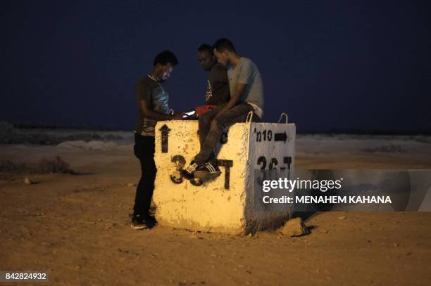 Detained African illegal immigrants spend their free time outside the Holot detention center in Israel's southern Negev desert, near the Egyptian...