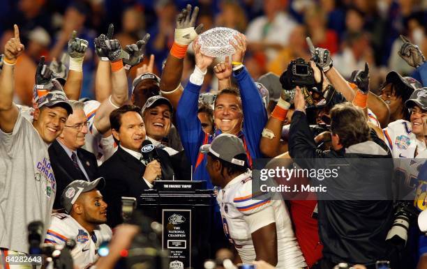 Head coach Urban Meyer of the Florida Gators holds the championship trophy at the podium following the game against the Oklahoma Sooners at the FedEx...