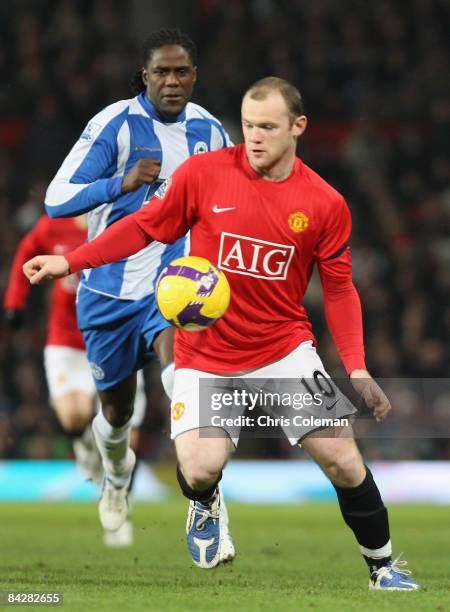 Wayne Rooney of Manchester United clashes with Mario Melchiot of Wigan Athletic during the Barclays Premier League match between Manchester United...