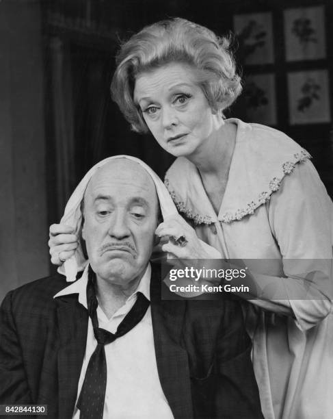 Actress Evelyn Laye administers to Fred Clark's hangover in a rehearsal for the comedy 'Never Too Late' at the Prince of Wales Theatre in London,...