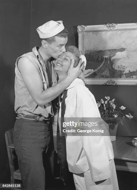 American actor Larry Hagman kisses his mother, actress and singer Mary Martin, before appearing in the stage musical 'South Pacific', 1951. She is in...