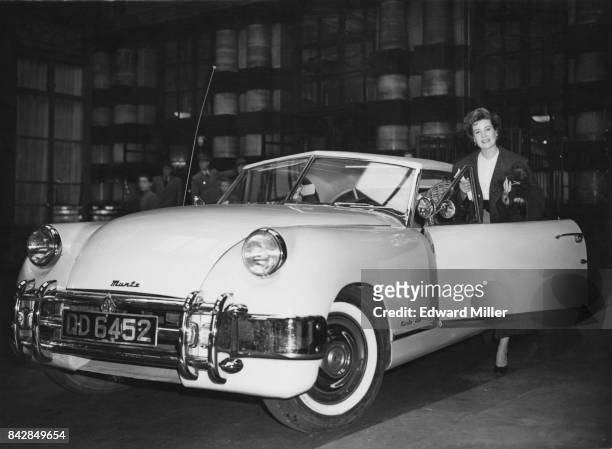 American actress Gloria DeHaven gets into her pink Muntz Jet outside the Savoy Hotel in London, bound for Dover and the Continent, 22nd April 1952.