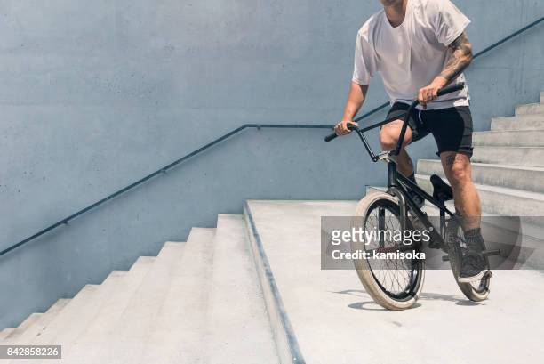 young bmx bicycle rider - bicycle stunt stock pictures, royalty-free photos & images