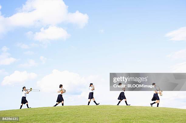 female students playing musical instruments, walking in line - female high school student 個照片及圖片檔