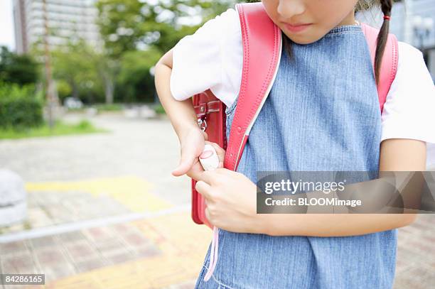 girl student attaching security alarm to satchel, mid section - alarm system stock pictures, royalty-free photos & images