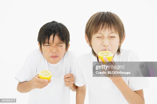 boys eating lemons, studio shot - sour expression stock pictures, royalty-free photos & images
