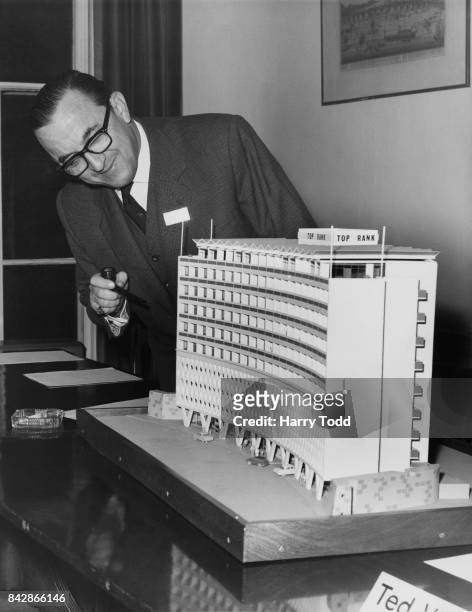 Sir Joshua Hassan , the Chief Minister of Gibraltar, inspects a model of a motor hotel in London, 24th November 1964. The hotel will be built in the...