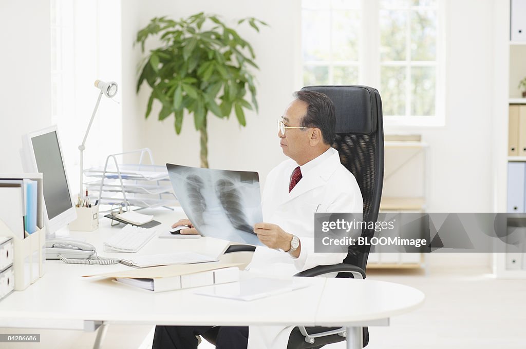 Senior male doctor looking at x-ray