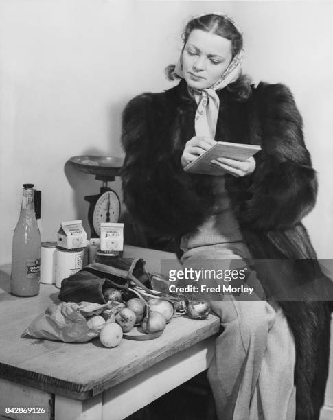 Actress Victoria Hopper checks her groceries after a shop, UK, 23rd November 1946. She is starring in 'Vanity Fair' at the Comedy Theatre in London.