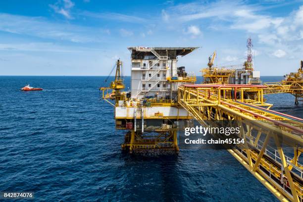 platform offshore oil and gas processing platform for oil and gas industry to treat gases and sent to onshore refinery, petrochemical and power generation plant with transportation boat. industry concept. - greenhouse gas stock-fotos und bilder